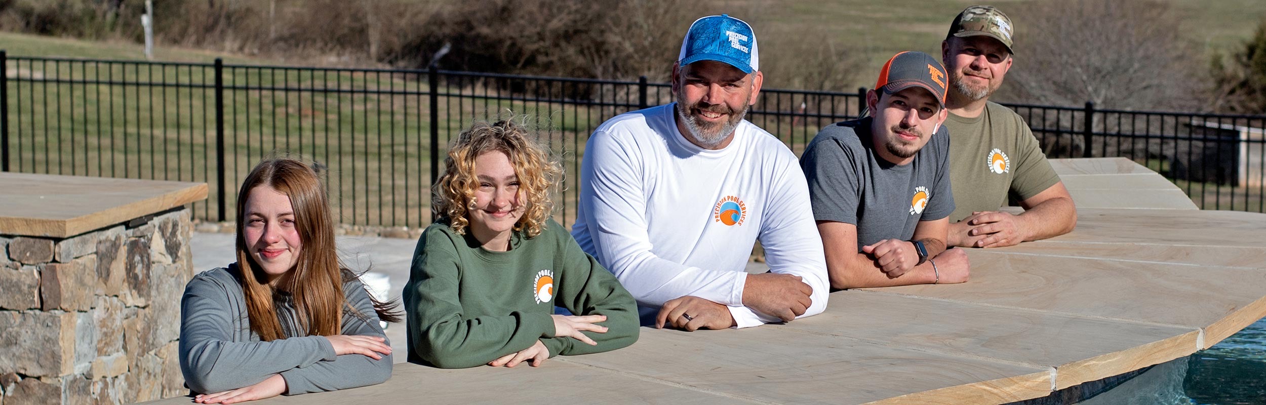 The Precision Pool Services crew at a stone pool bar